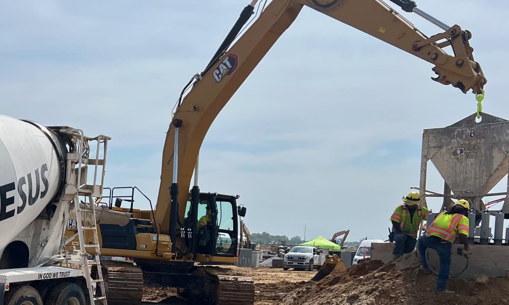 Pokie's mixer and excavator working a foundation pour on a job site