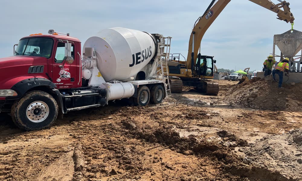 Pokie's mixer delivering on a large commercial job site with excavator