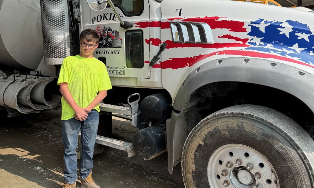 Pokie's crew member beside flag-wrapped mixer truck number 1